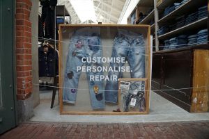 A display of jeans showing a beautiful array of decorated repairs. Text reads "Customise. Personalise. Repair."