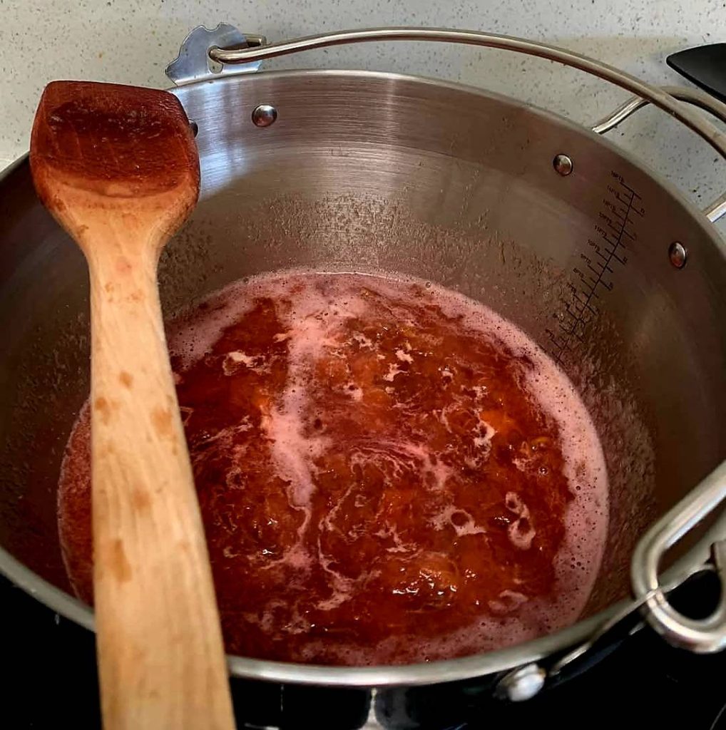 Plums in jam pan simmering being brought up to temperature